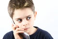 Afraid little boy speaking on the phone in white background