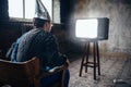 Afraided man in aluminum foil helmet sits in chair