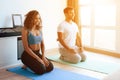 Aframerican couple doing yoga exercises at home. They sit on the floor on mats for yoga.