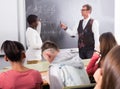 Aframerican student answers near blackboard at math lesson