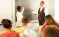 Aframerican student answers near blackboard at math lesson