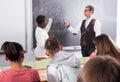 Aframerican student answers near blackboard at math lesson