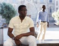 Aframerican traveler in glasses resting on bench during walk Royalty Free Stock Photo