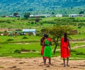 Africa, Kenya, Masai Mara, warriors chat near their village on Savanna