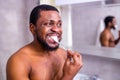 africa man toothbrush in bathroom looking at mirror Royalty Free Stock Photo