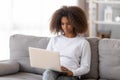 African adolescent girl sitting on couch using computer