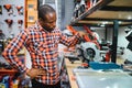 African americam man buying modern electric drill while standing in tool. Hardware construction site objects concept Royalty Free Stock Photo