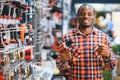 African americam man buying modern electric drill while standing in tool. Hardware construction site objects concept Royalty Free Stock Photo
