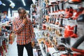 African americam man buying modern electric drill while standing in tool. Hardware construction site objects concept Royalty Free Stock Photo