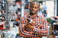 African americam man buying modern electric drill while standing in tool. Hardware construction site objects concept Royalty Free Stock Photo