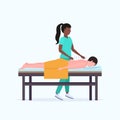 African american acupuncturist holding needle man patient getting acupuncture treatment guy relaxing lying on bed Royalty Free Stock Photo