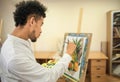 African-American artist painting still life in workshop