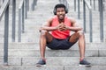 African american athletic guy listens to music in wireless headphones and smiles outdoors Royalty Free Stock Photo