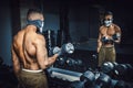 African american athletic man lifting dumbbells and working on his biceps in front of the mirror at the gym. black man in gym doin Royalty Free Stock Photo