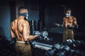 African american athletic man lifting dumbbells and working on his biceps in front of the mirror at the gym. black man in gym doin Royalty Free Stock Photo