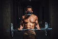 African american athletic man in mask looking at camera and lifting barbell on biceps. Exercise for biceps with barbell. black man Royalty Free Stock Photo