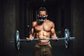 African american athletic man in mask looking at camera and lifting barbell on biceps. Exercise for biceps with barbell. black man Royalty Free Stock Photo