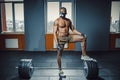 African american athletic man in sport mask put his foot on barbell waiting and preparing before lifting heavy barbell. deadlift w Royalty Free Stock Photo