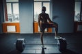 African american athletic man in sport mask put his foot on barbell waiting and preparing before lifting heavy barbell. deadlift w Royalty Free Stock Photo