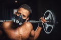 African american athletic strong man holding barbell on shoulders in gym. black man poses with barbell in gym close-up Royalty Free Stock Photo