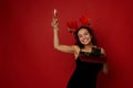 African American beautiful woman wearing stag antler hoop and black velvet dress holds gift boxes wrapped in shiny red green paper