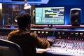 African american audio expert operates editing software to adjust sound settings