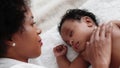 African american baby boy sleeping on bed while mother watching with love
