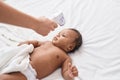 African american baby measuring temperature at bedroom Royalty Free Stock Photo