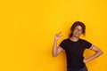 African-american beautiful young woman`s portrait on yellow studio background, emotional and expressive. Copyspace for