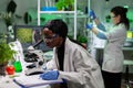 African american biologist scientist analyzing genetic mutation on leaf sample