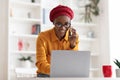 African american bisinesswoman having phone conversation, checking laptop