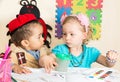 African American black boy and girl drawing with colorful pencils in preschool in kindergarten Royalty Free Stock Photo