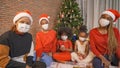 African American black family,women and kid girl daughters with face masks sharing gifts on Merry Christmas Eve Xmas Party. They Royalty Free Stock Photo