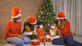 African American black family, women wearing face masks to their kid girl daughters. Gifts on Merry Christmas Eve Xmas Party. Royalty Free Stock Photo