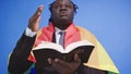 African american black man with elegant suit rainbow flag covering his shoulders holding holy bible in the hands. Gay Royalty Free Stock Photo