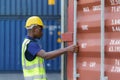 African-American black workers are opening containers for inspection and check that repairs have been completed in containers