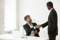 African-american boss congratulating caucasian employee with pro Royalty Free Stock Photo