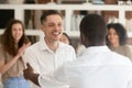 Black boss handshake congratulating excited Caucasian employee