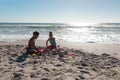 African american boy and girl making sandcastle together on shore at beach during sunny day Royalty Free Stock Photo