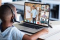 African american boy looking at students and teacher on laptop screen while studying online Royalty Free Stock Photo