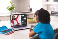 African american boy wearing headphones looking at laptop screen with girl student in online class Royalty Free Stock Photo