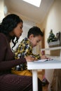 Time for educating. Mother and son at home.