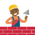 African-american bricklayer building a brick wall.