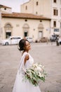 Wedding in Florence, Italy. African-American bride in a white dress and a long veil. With a magnificent bouquet of the