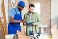 African american builder signs documents from the engineer Royalty Free Stock Photo