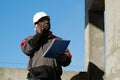 African american builder with work papers talks on smartphone