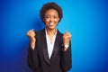 African american business executive woman over isolated blue background celebrating surprised and amazed for success with arms Royalty Free Stock Photo