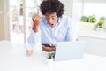 African American business man using smartphone and laptop annoyed and frustrated shouting with anger, crazy and yelling with Royalty Free Stock Photo