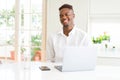 African american business man working using laptop looking away to side with smile on face, natural expression Royalty Free Stock Photo