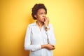 African american business woman over isolated yellow background looking stressed and nervous with hands on mouth biting nails
